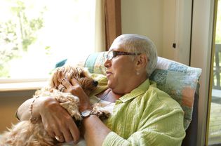 A caucasian woman holding a dog